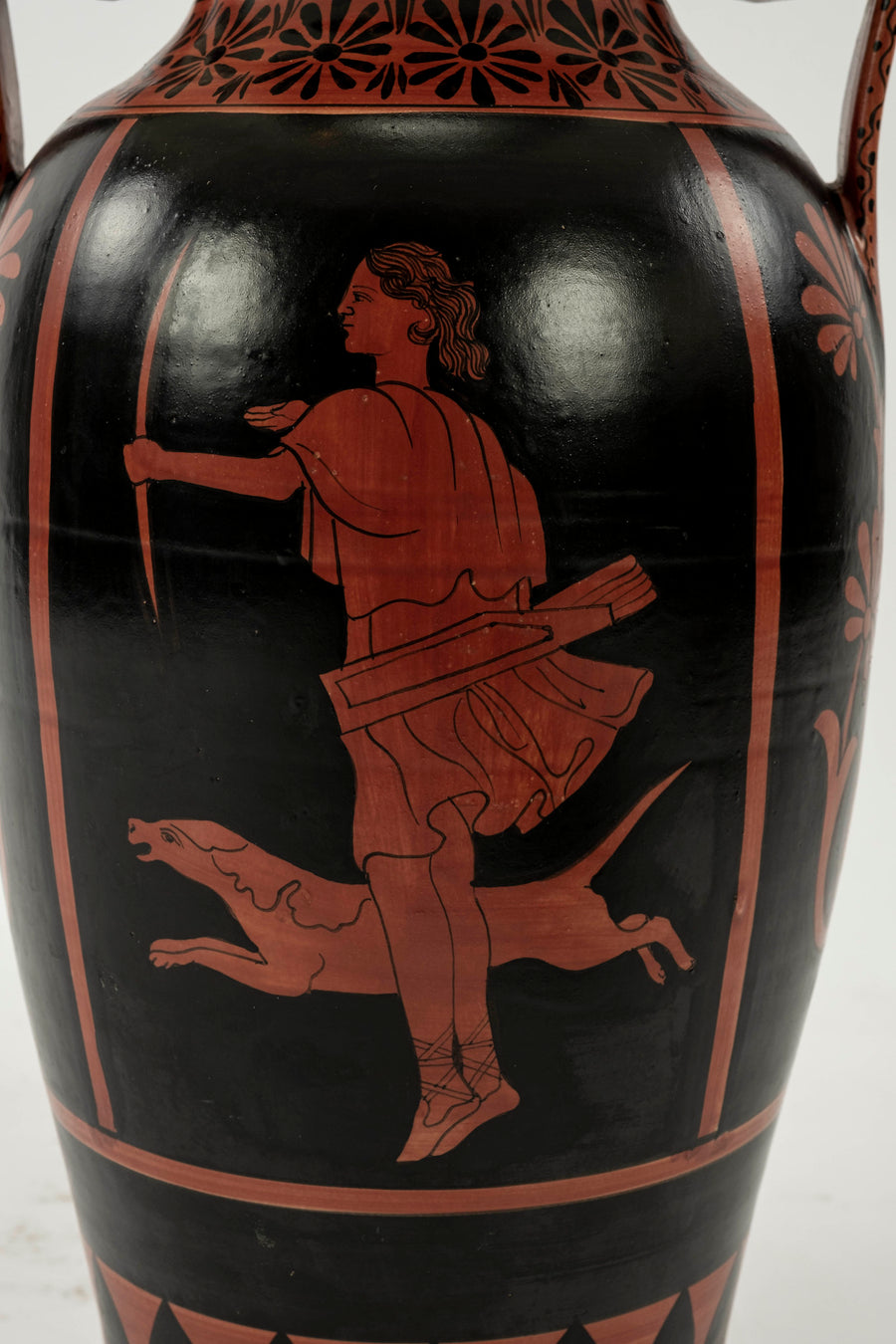 Up-close of the urn lamp's base featuring classic Etruscan artwork of a female archer with hunting dog and painted in classic red on black.