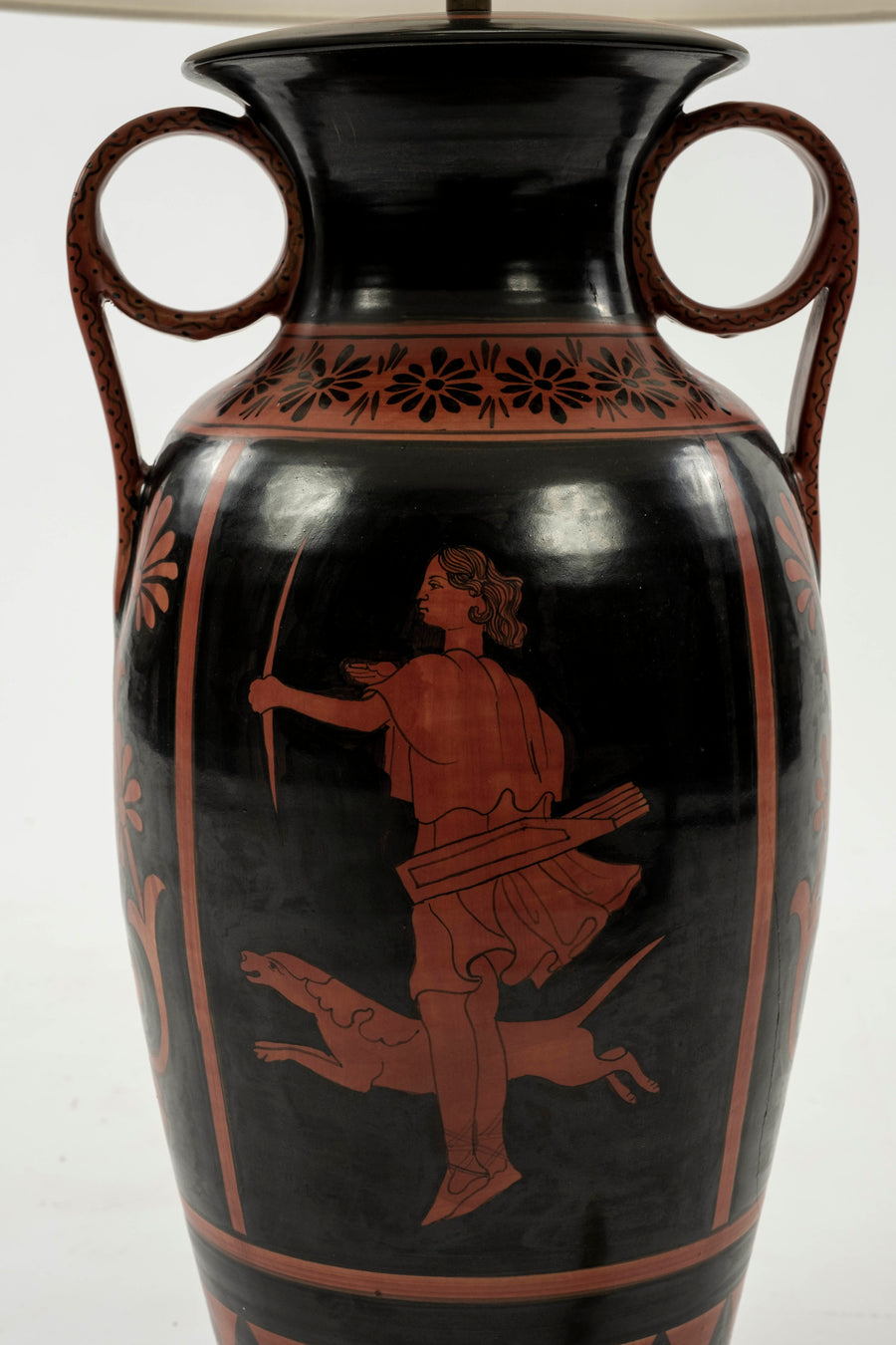 Up-close of the urn lamp's base featuring classic Etruscan artwork of a females archer with hunting dog painted in classic red on black.